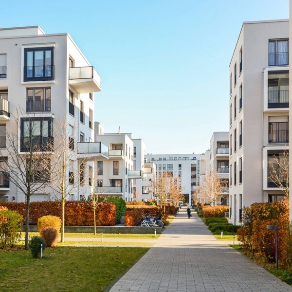 Wohnsiedlung mit modernen Mehrfamilienhäusern und in der Mitte ein Spazierweg